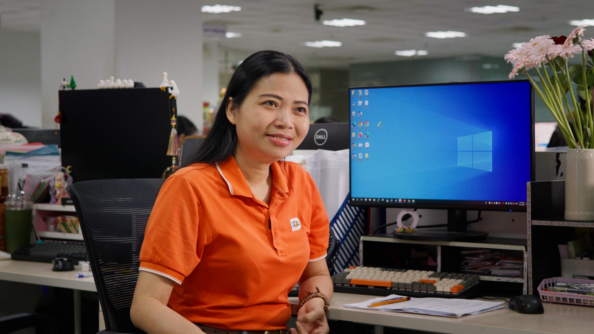 FPT Telecom employee smiling at her desk during an interview